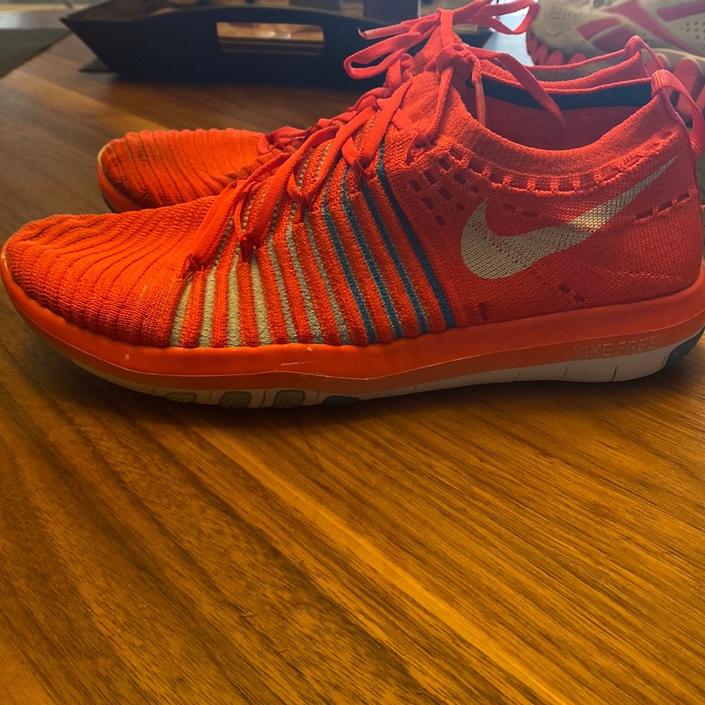 Women’s Nike free running shoe. Size 7.5. Bright red collar with blue stripes.